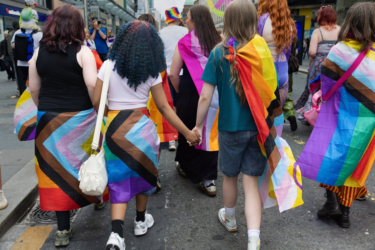 Participants in a pride parade displaying vibrant rainbow colors