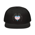 Flaunt It black snapback cap featuring a line-art graphic of hands holding a trans pride flag heart.