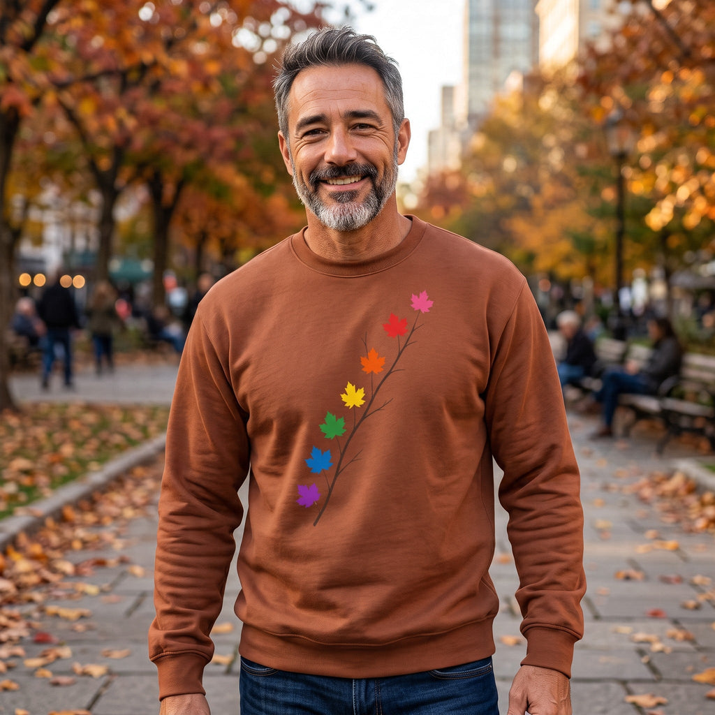 Man wearing a brown Flaunt It long sleeve shirt with a pride maple leaf branch design in a park during autumn.