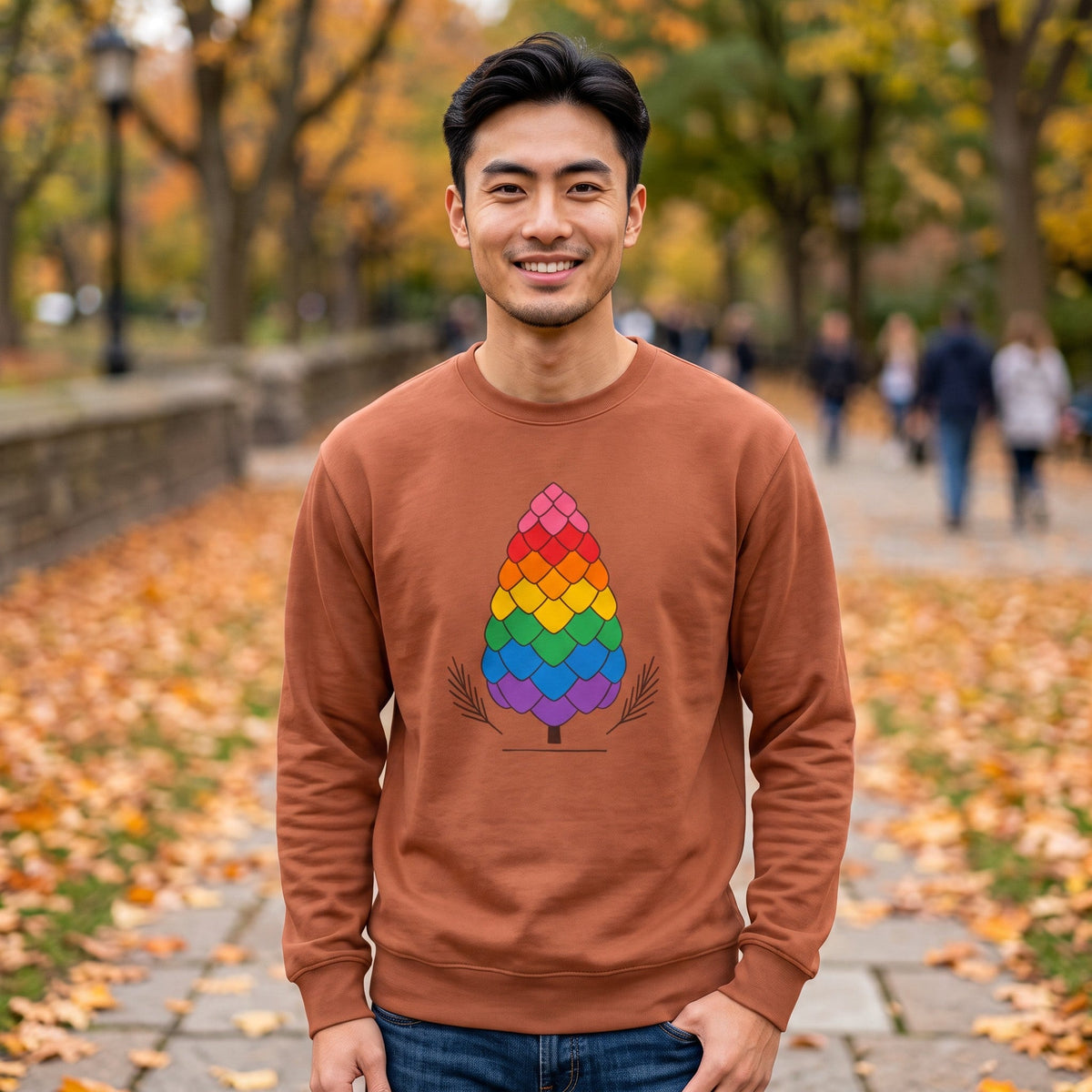 Flaunt It brown heavyweight long sleeve shirt with a rainbow pinecone graphic, worn by a man in an autumn park.