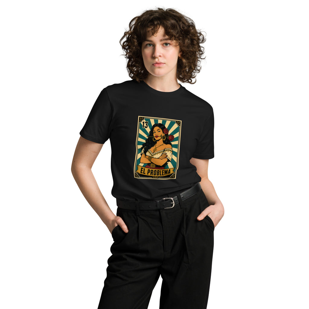 Front view of a smiling model wearing a black El Problema premium unisex T-shirt with a vintage loteria card design of a woman with roses, EL PROBLEMA text and number 13.