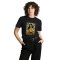 Front view of a smiling model wearing a black El Problema premium unisex T-shirt with a vintage loteria card design of a woman with roses, EL PROBLEMA text and number 13.