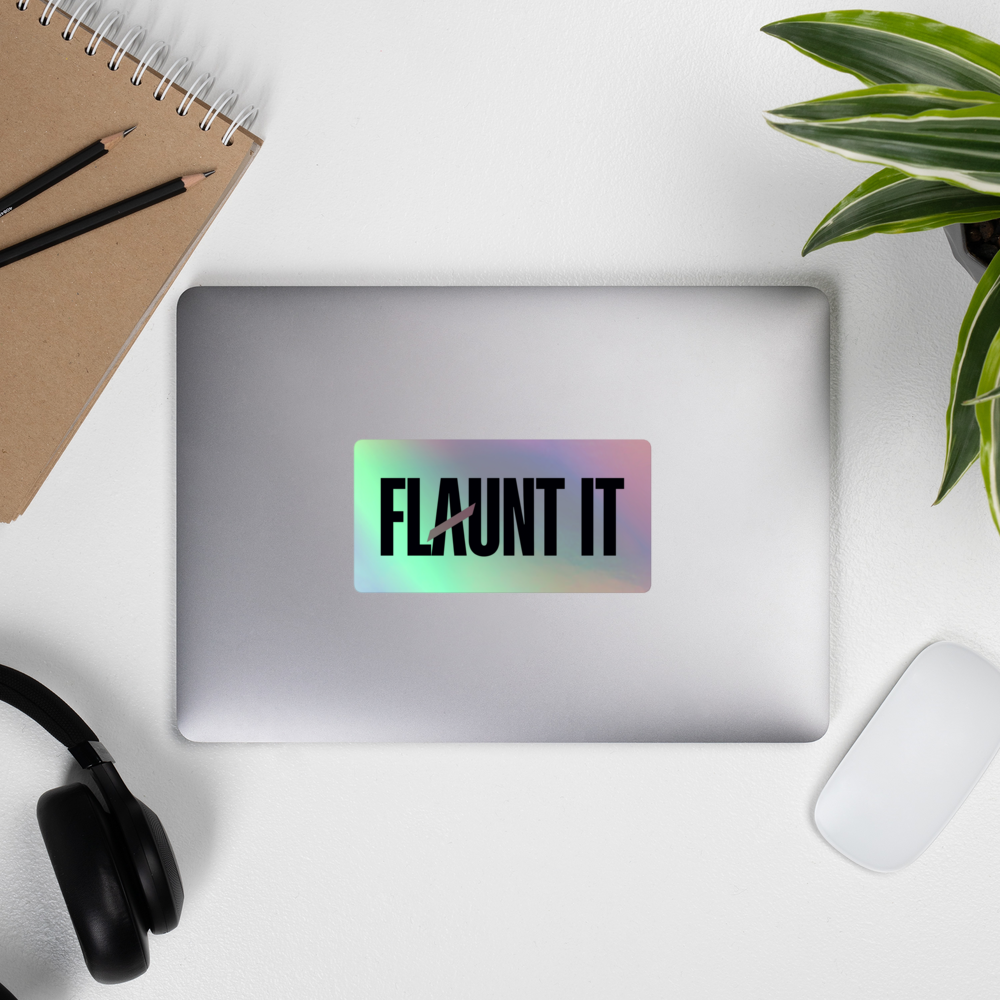 Flaunt It holographic vinyl sticker with 3D embossed logo applied to a silver laptop on a desk