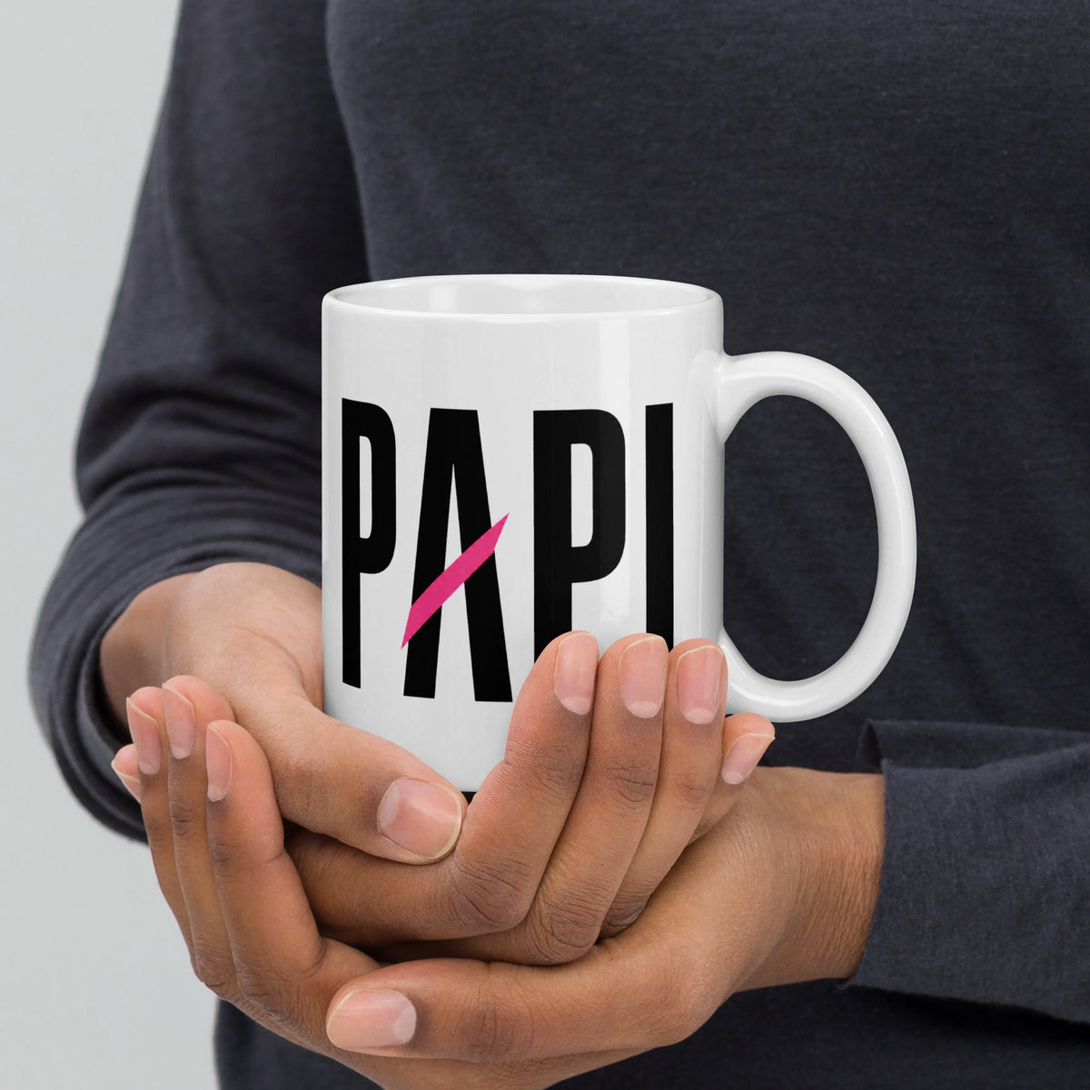 Flaunt It white ceramic mug held in hands featuring bold black PAPI text with a signature pink slash design.