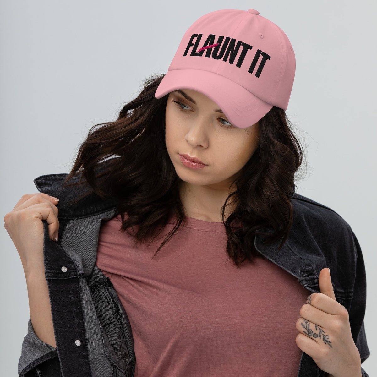 Flaunt It unisex pink cotton twill baseball cap with black embroidered wordmark logo worn by a woman