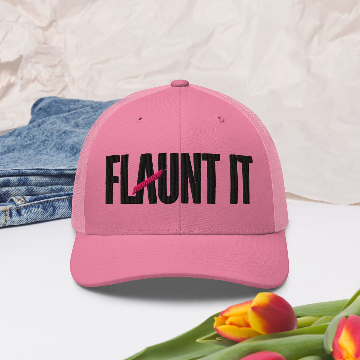 Flaunt It pink mesh-back trucker hat with bold black embroidered wordmark logo and curved visor