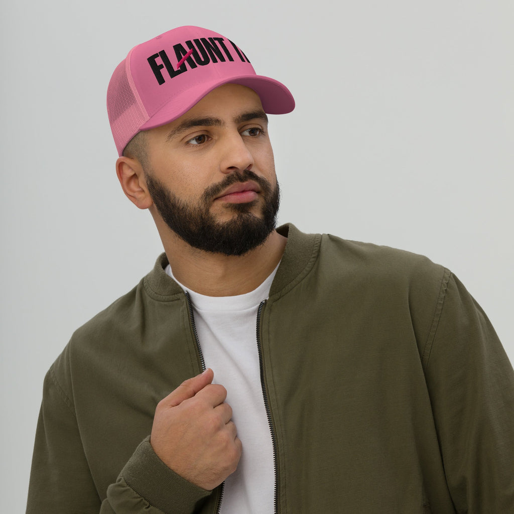 A man wearing a pink Flaunt It mesh-back trucker hat with black embroidered logo and a curved visor.