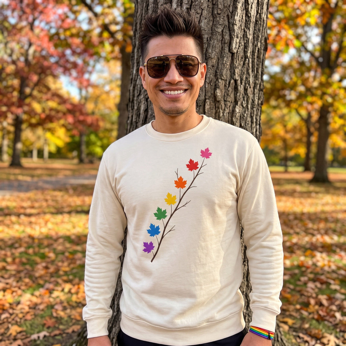 Flaunt It unisex heavyweight long sleeve shirt in cream with a pride maple leaf branch graphic, worn by a man.