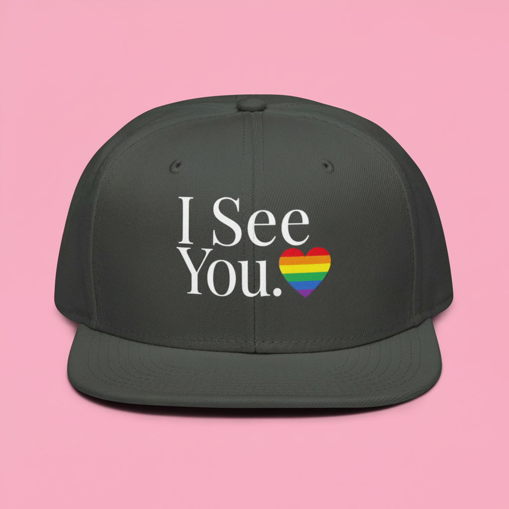 Flaunt It I See You Pride snapback cap with rainbow heart graphic on a woman in a park setting