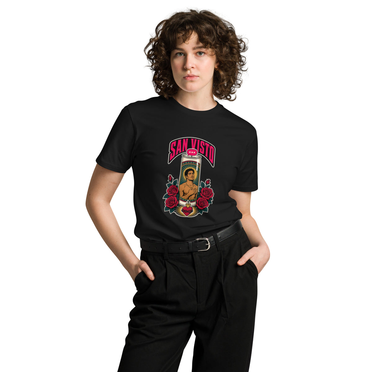 Front view of a model wearing a black San Visto premium unisex T-shirt with a devotional prayer-candle illustration of a male saint, pink SAN VISTO headline, red roses and a sacred heart.