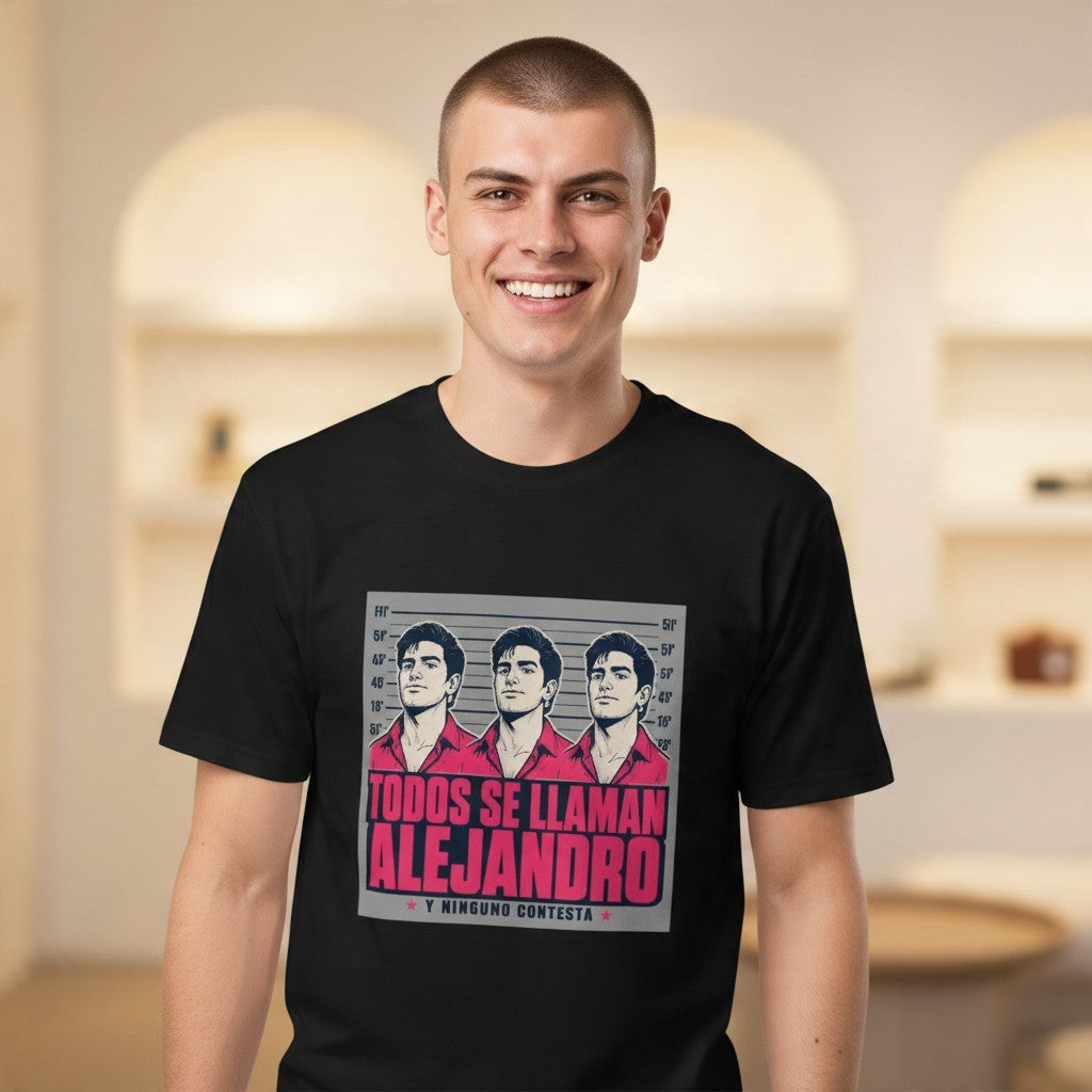 Close-up front view of a smiling male model wearing the black Todos Se Llaman Alejandro Premium Unisex T-Shirt with a poster panel, pink TODOS SE LLAMAN ALEJANDRO headline, Y NINGUNO CONTESTA sub-line and a height-chart lineup of three identical men in red shirts, in a warm studio background.