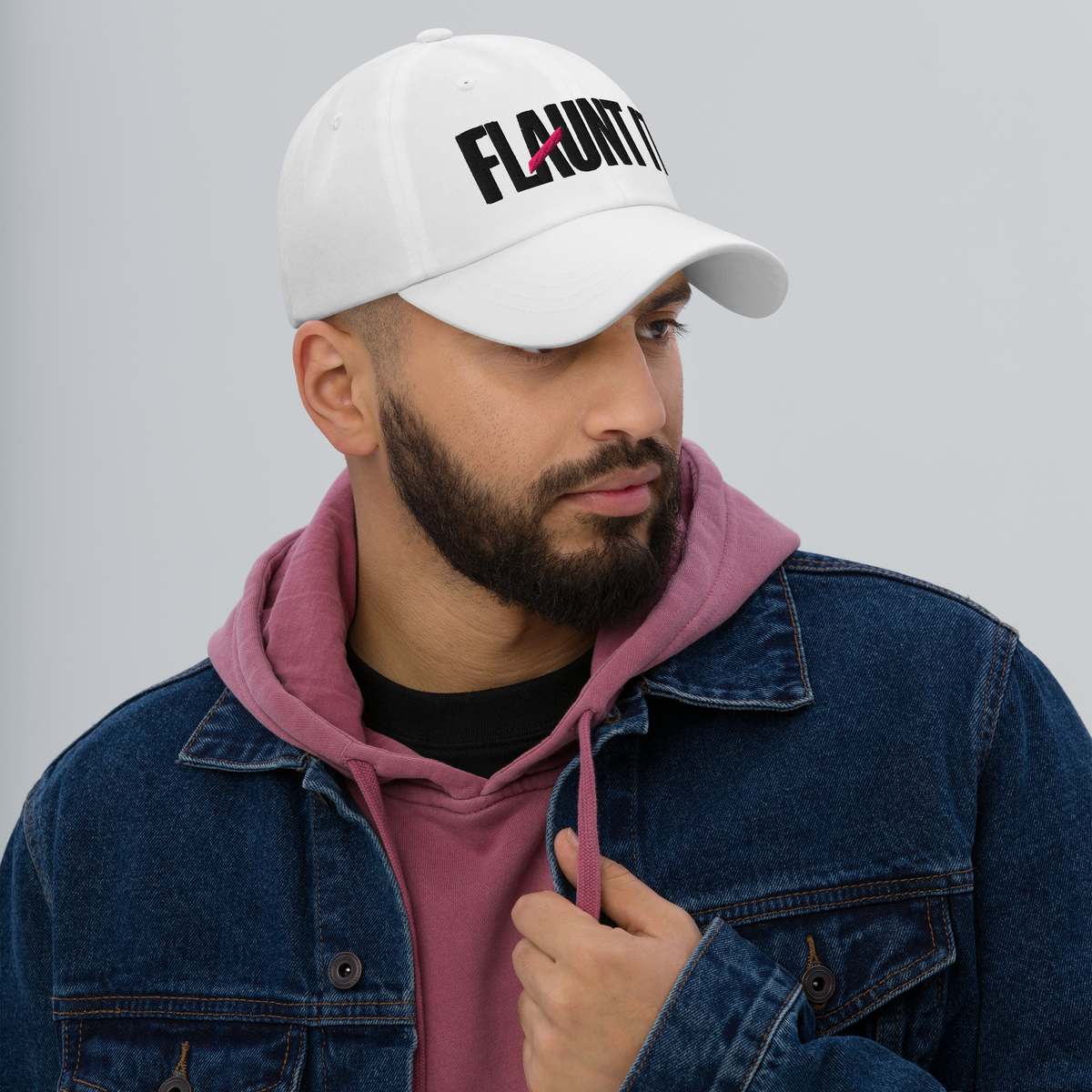 Flaunt It white unstructured 6-panel cotton twill hat with embroidered black logo worn by a man in a denim jacket